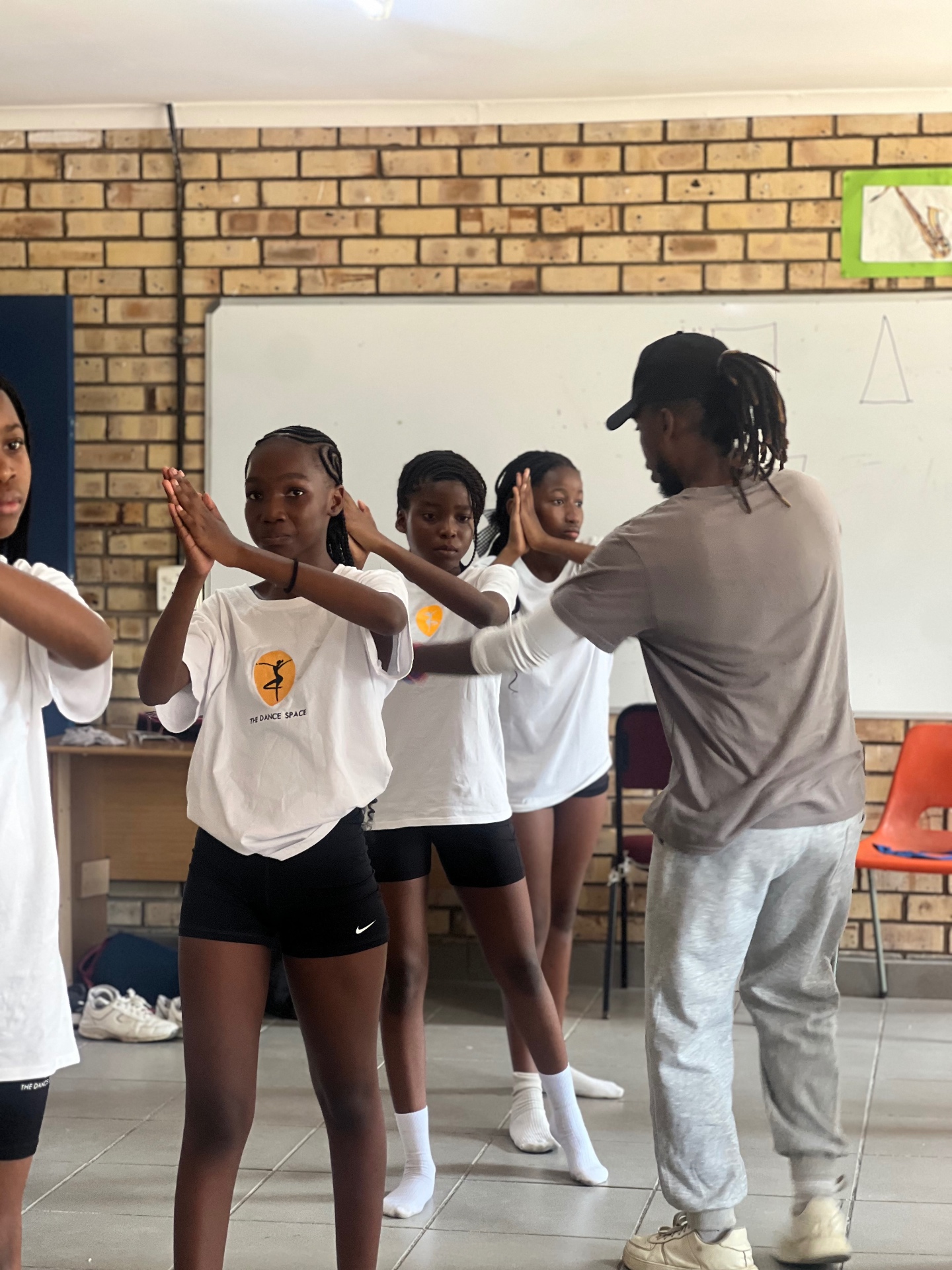 Students learning choreography with their instructor in a school hall