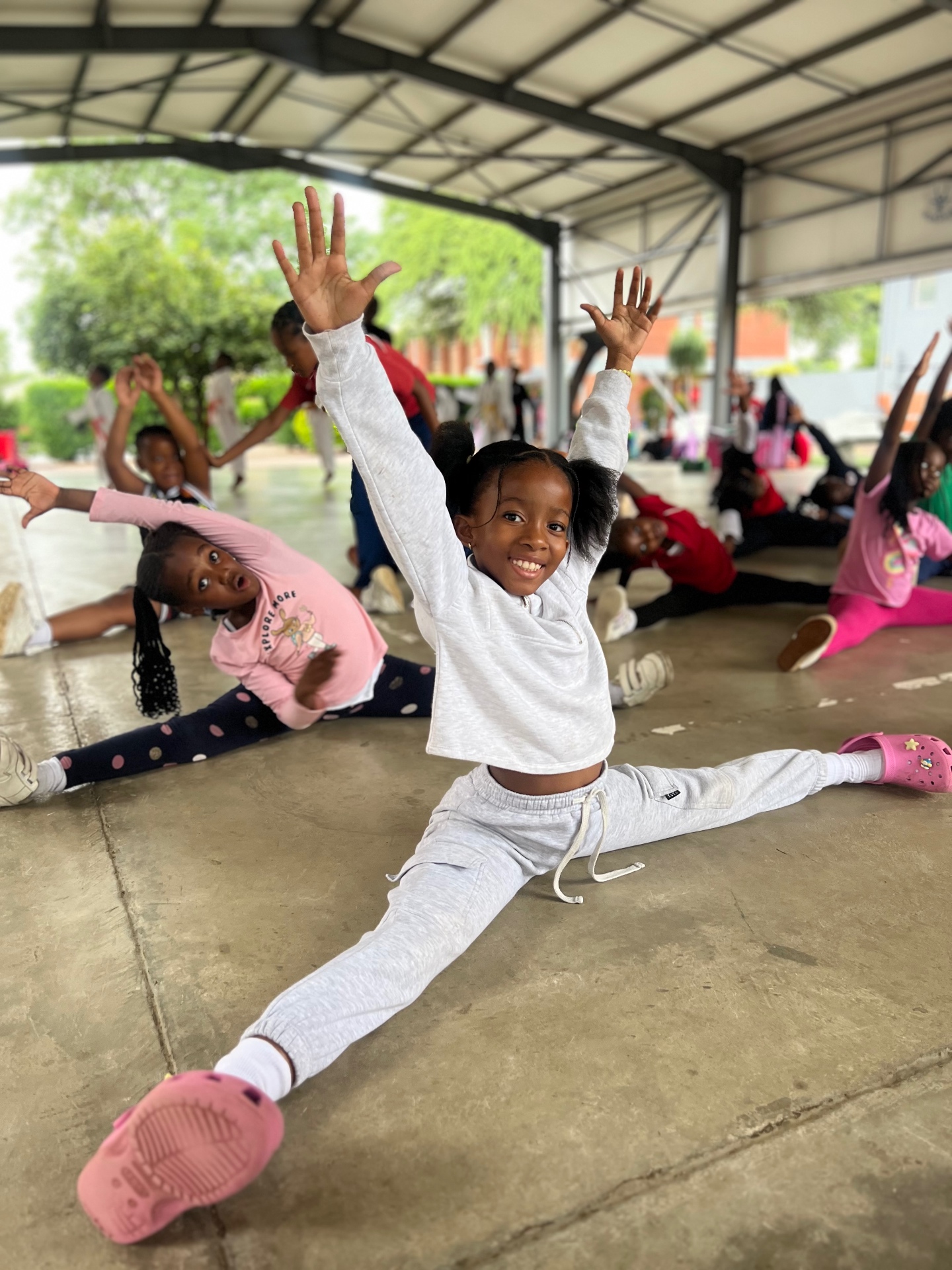 A young dancer beaming in the splits during a warm-up class